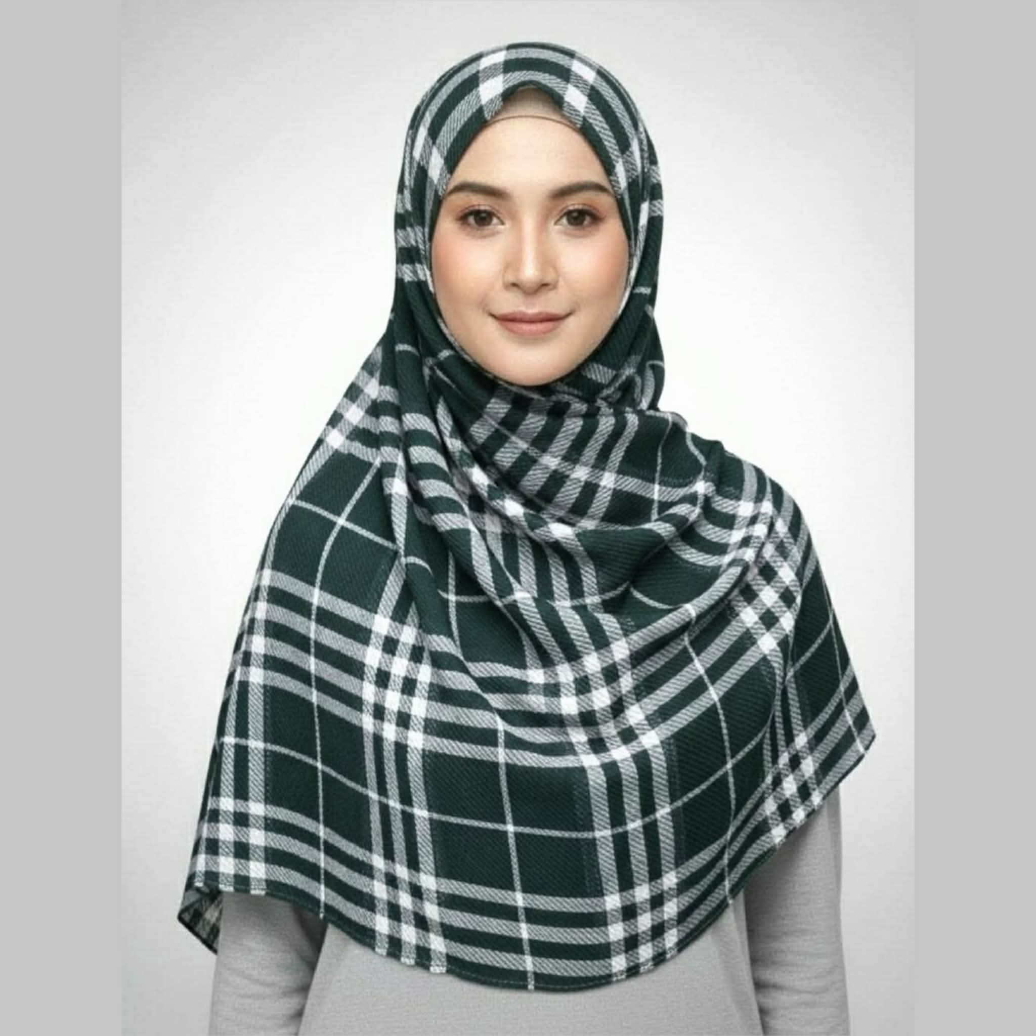 A woman wearing a green and white plaid crepe print hijab scarf, size 80x33 inches.