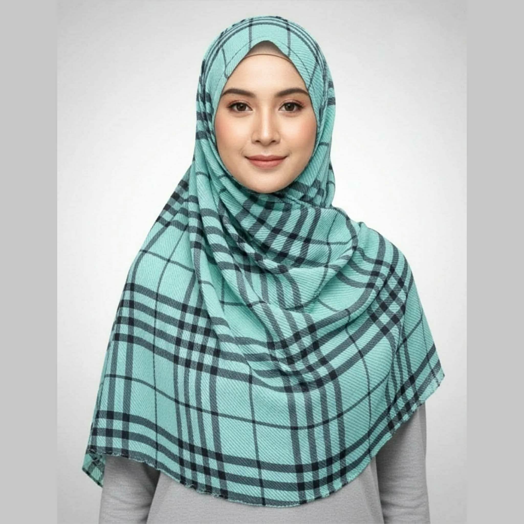 Woman wearing a mint green checkered crepe printed hijab with black lines